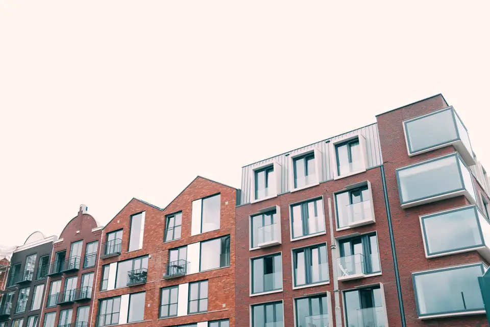 Mehrgeschossiger Wohnungsbau aus rotem Klinker mit umlaufenden Balkonen, von unten aufgenommen